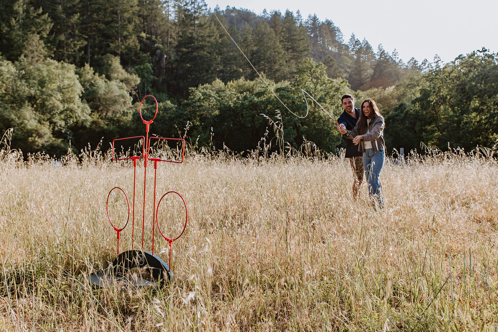 couple playing hoeyhole game in field