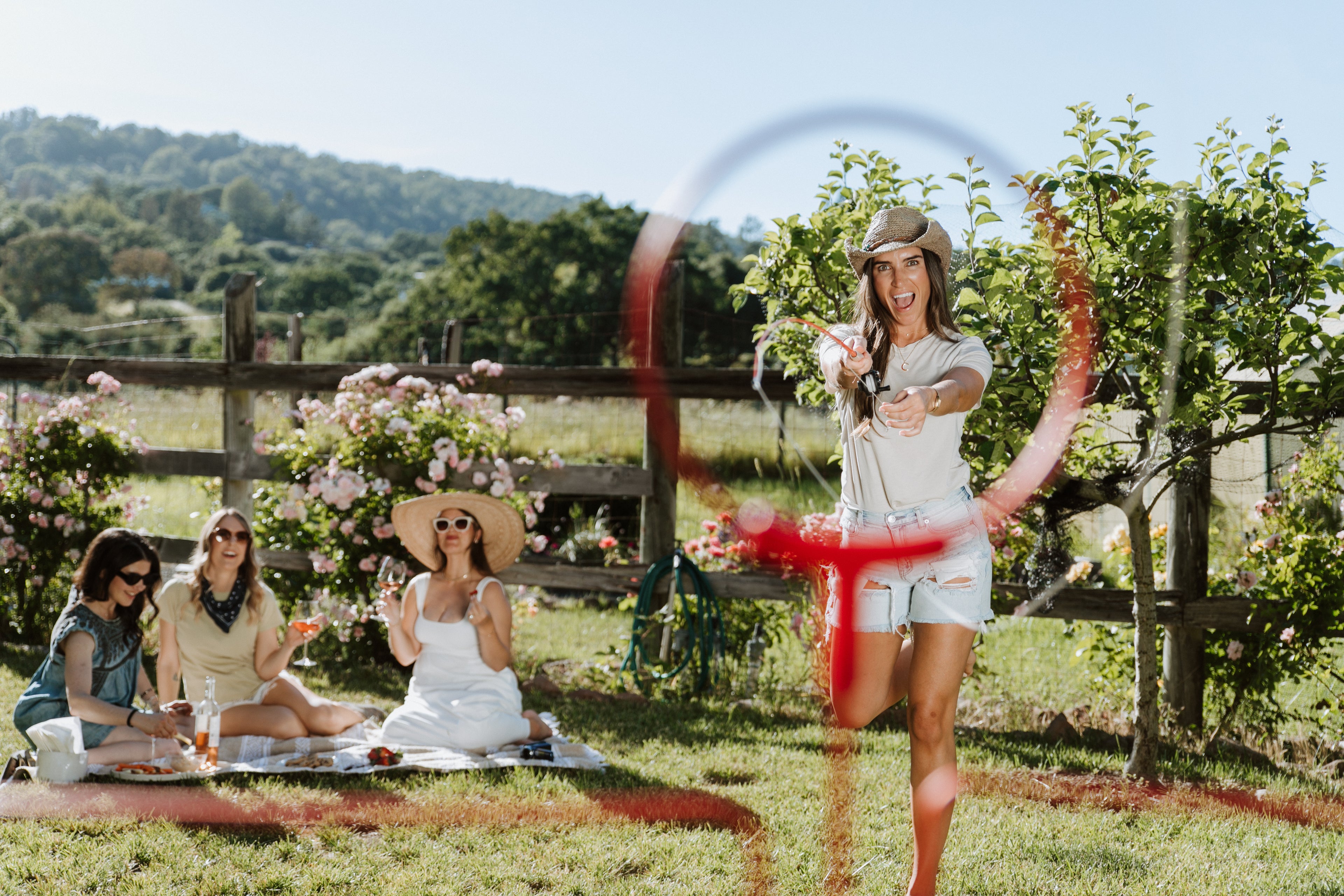 girl in backyard playing honeyhole at a picnic